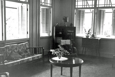 Singapore Naval Base Housing - 29 Admiralty Road Interior 1965
29 Admiralty Road (Changed to Admiralty Road East around 1970). Photo shows the open plan construction to allow good ventilation. Very secure being built high on stilts, all windows and balcony's fitted with either louvered openings or 'chiks' (drop down cane blinds). The room is show furnished with standard MoD issued furniture that could be drawn from Naval Stores for the duration of tenancy.  
